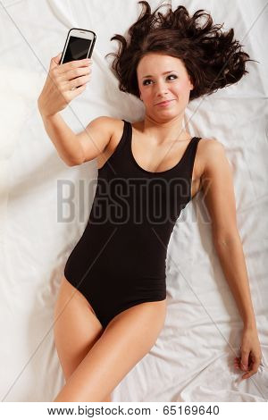 Sexy Lazy Girl Lying With Phone On Bed In Bedroom
