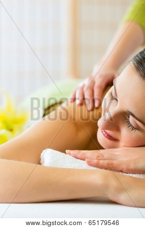 Beautiful woman having a wellness back massage and feeling visibly good about it