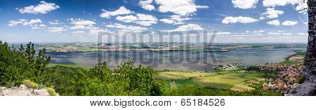 Spring Countryside With Lake, Village And Blue Sky With Clouds