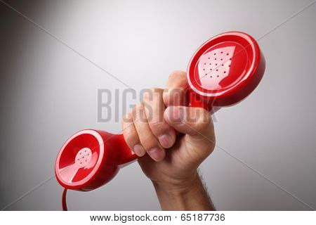 Red old fashioned telephone receiver on gray background concept for customer support line or important call 