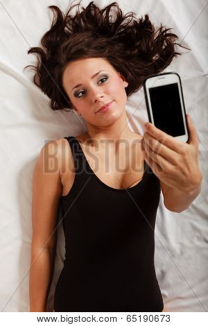 Sexy Lazy Girl Lying With Phone On Bed In Bedroom
