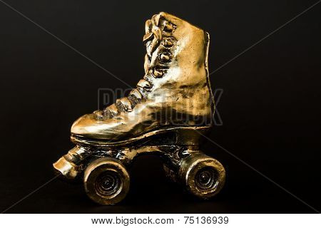 Golden Roller Skate Against Black Background