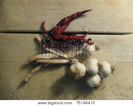 Garlic and chilli on wooden board.