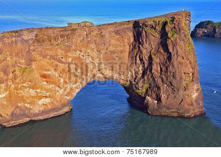 Cape Dyrholaey in southern Iceland. Sunset in July. The colossal rock in the sea in the form of an elephant