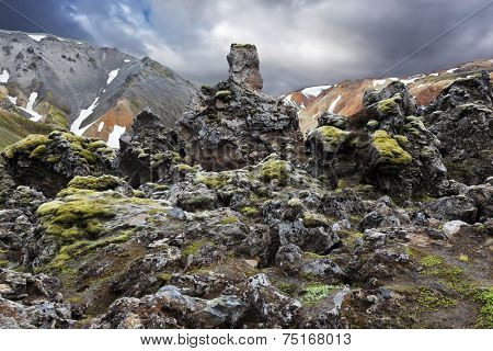 National Park Landmannalaugar in Iceland. Pieces of gray and black lava bizarre shapes, sometimes covered with green moss
