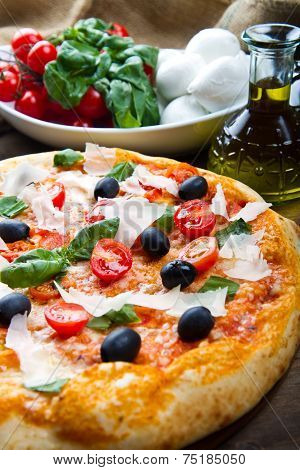 delicoius fresh pizza with tomatoes, olives and basil