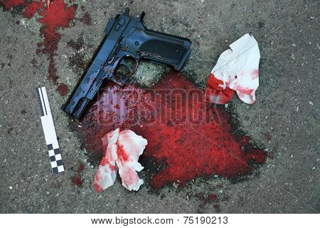 Gun and blood at crime scene 