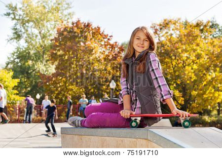 Cute girl with long hair and red skateboard