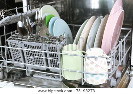 Open dishwasher with clean utensils in it