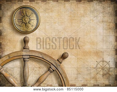steering wheel and compass with vintage nautical map