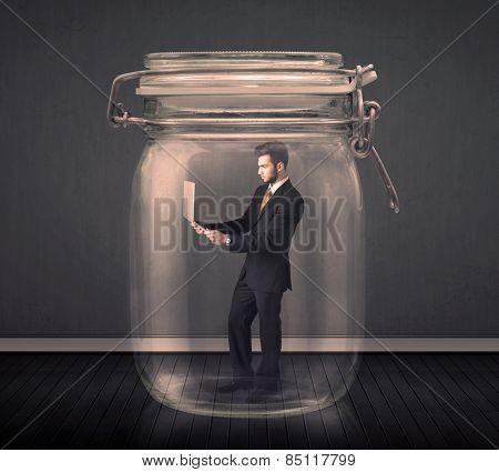 Businessman trapped into a glass jar concept on background