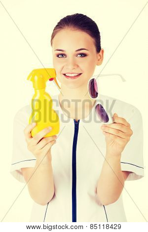 Woman doctor or nurse showing sunscreen and sunglasses.