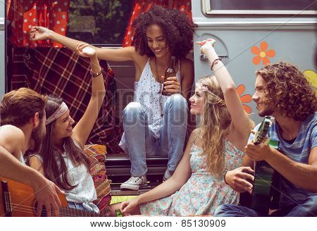 Hipster friends by camper van at festival on a summers day
