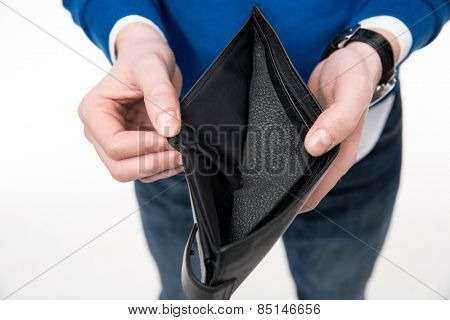 Closeup image of a man holding emty wallet over white background