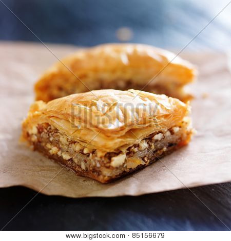 two pieces of baklava on wax paper