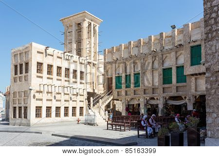 DOHA, QATAR - MARCH 8, 2015: Porters await work outside part of the imposing Souq Waqif tourist attraction