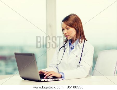 medicine and healthcare concept - busy doctor with laptop computer