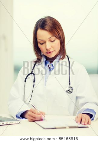medicine and healthcare concept - busy doctor with laptop computer