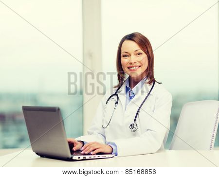 medicine and healthcare concept - busy doctor with laptop computer