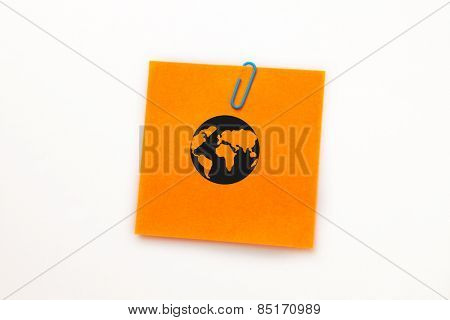 Earth against orange adhesive note with a paperclip