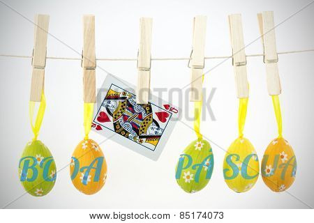 boa pascua against easter eggs hanging from a line with queen of hearts