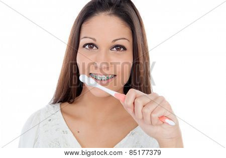 Attractive young woman with brackets cleaning her teeth isolated on a white backgroung