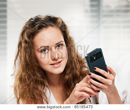 Radiant woman with phone lying on bed