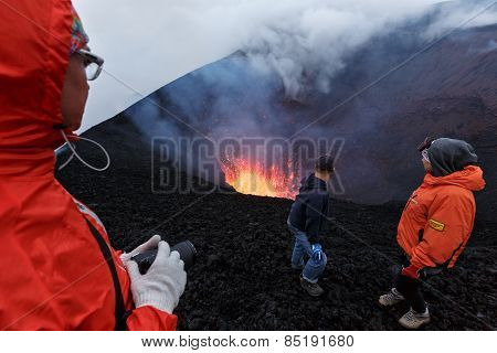 Eruption Tolbachik Volcano On Kamchatka, Travelers Watching The Lava Lake In Crater Of Volcano