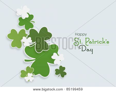 Happy St. Patrick's Day celebration with Irish lucky shamrock leaves on blue background.
