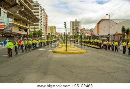 Quito city street closed off by long line police officers awaiting Pope Francis motorcade to arrive,