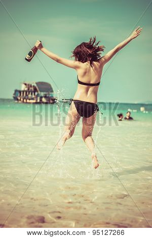 Sexy Asian Thai Girl In Bikini Is Jumping With Joy On The Seashore Of Pattaya Sea With Alcohol Bottl