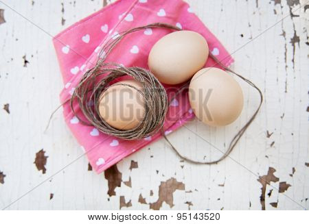 Eggs on tablecloth over wooden background