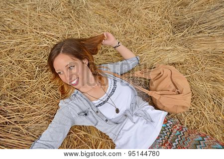 Happy Girl Lying On A Straw Pile
