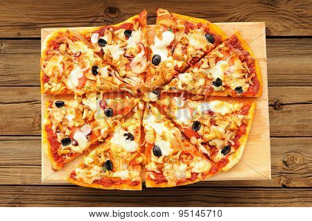Al Funghi Pizza With Olives Cut In Sectors On Wooden Board