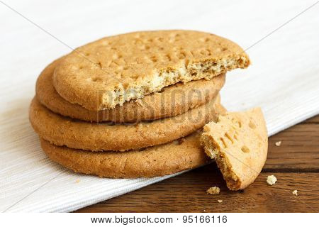 Stack Of Sweetmeal Digestive Biscuits On Dark Wood And Napkin.