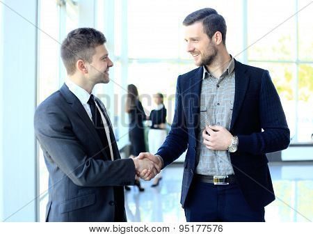 Businesss And Office Concept - Two Businessmen Shaking Hands In Office