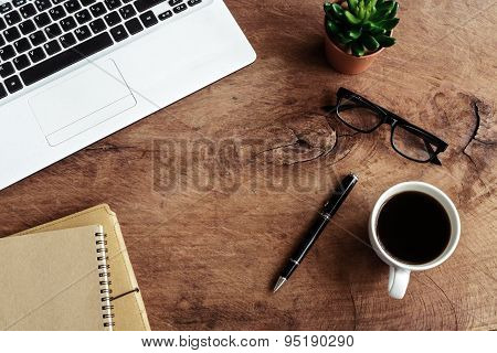 Laptop With Notebook And Cup Of Coffee On Old Wooden Table