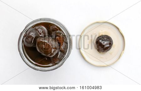 picture of an open jar of preserved figs on white background