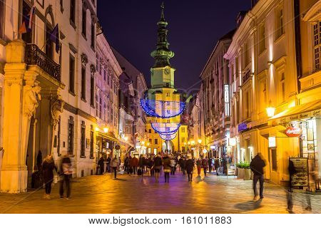 BRATISLAVA SLOVAKIA - 4TH DECEMBER 2016: Stara radnica and Bratislava Christmas Market at night. The Blur of people can be seen.