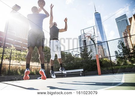 Two afroamerican athlethes playing basketball outdoors - Basketball athlete training on court in New York