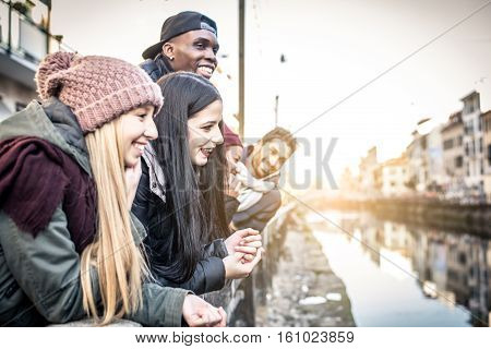 Group of multi-ethnic friends walking on the streets and smiling - Young people having fun outdoors