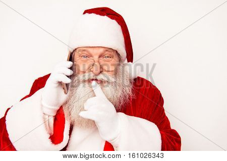 Portrait Of Happy Santa Claus Talking On Phone And Showing Shh Gesture