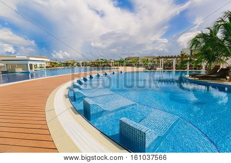 Cayo Guillermo island, Iberostar Playa Pilar hotel, Cuba, June 28, 2016, nice beautiful inviting view of a curved comfortable swimming pool with ceramic pool beds and people relaxing, in background