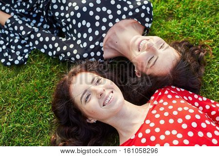 Beautiful Twin Sisters Lying On The Grass