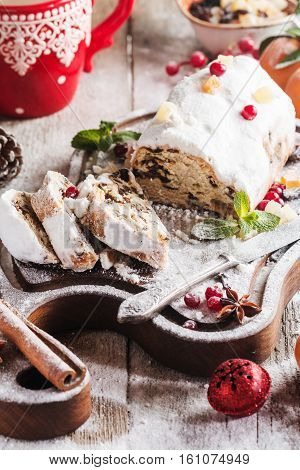 Christmas stollen, traditional German, European festive dessert cut into pieces on wooden background.