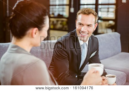 Businessman and businesswoman having a discussion during breaktime in office