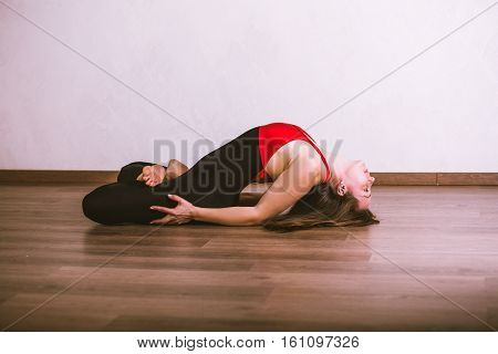 Young pretty woman in black leotard practicing yoga