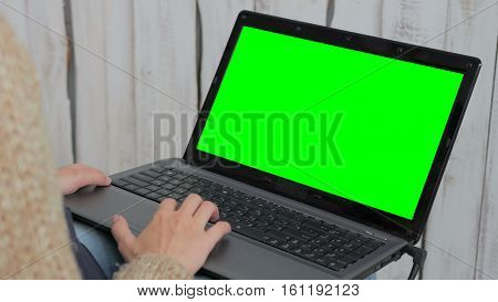 Woman using laptop with green screen. Business, communication, freelance and internet concept