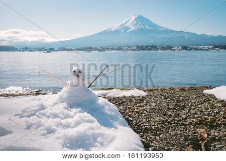 Snowman Standing In Winter Landscape On Fuji Moutain Background At Kawaguchiko Lake, Japan