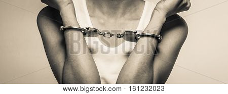 closeup young woman with handcuffs, violence or internment concept background